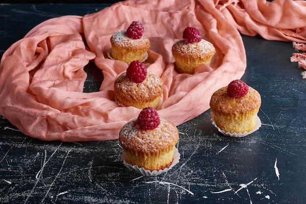 Cupcakes com açúcar em pó e frutas vermelhas.