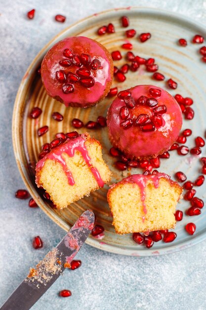 Cupcakes com cobertura e sementes de romã.