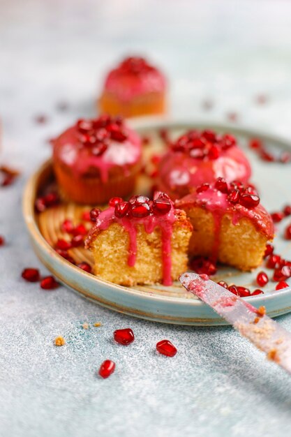 Cupcakes com cobertura e sementes de romã.