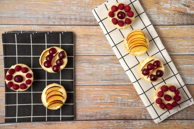 Cupcakes de baunilha com frutas vermelhas do verão na toalha preta e branca