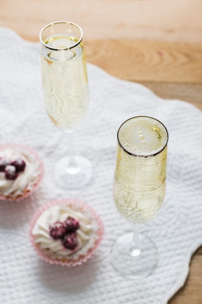 Foto grátis cupcakes e copos de vinho branco de alta vista