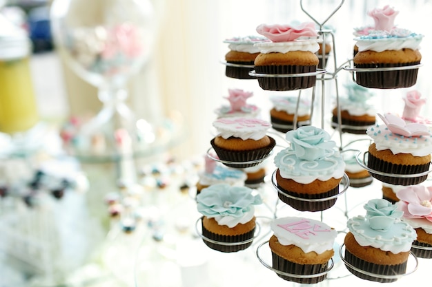 Foto grátis cupcakes saborosos com rosas de esmalte rosa e azul colocam os detentores