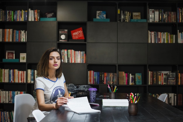 Cute girl sitting on table flipping page