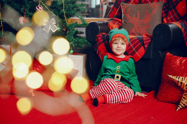 Cutte menino em casa perto de decorações de natal