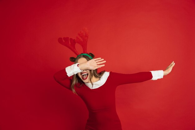 Dabbing, dab. Conceito de Natal, Ano Novo, clima de inverno, feriados. Linda mulher caucasiana com cabelo comprido como a caixa de presente pegando renas do Papai Noel.