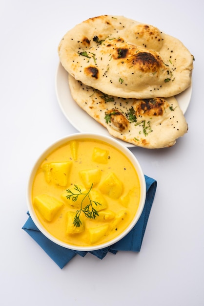 Dahi wale aloo ou aaloo ou iogurte ou curry de batata requeijão um prato clássico indiano servido em tigela com foco seletivo naan Foto Premium