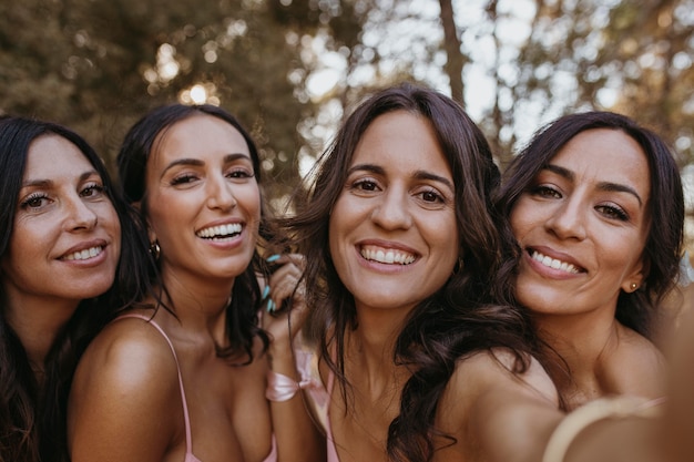 Damas de honra em vestidos bonitos celebrando o casamento ao ar livre