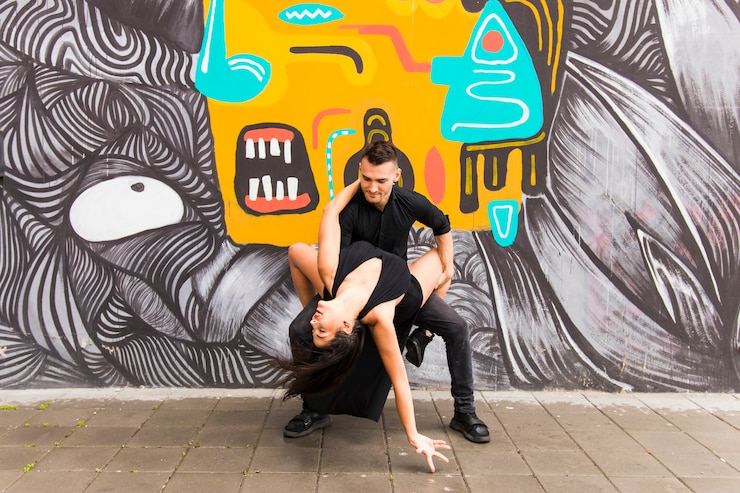 Foto grátis dançarina de rua urbana contemporânea dançando na frente de graffiti