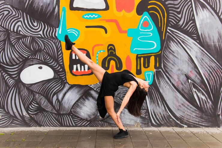 Foto grátis dançarino feminino de tango posando contra parede criativa graffiti