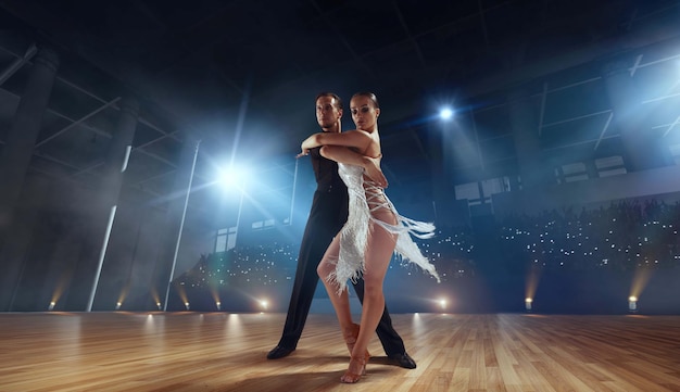 Dançarinos de casal realizam dança latina em grande palco profissional Dança de salão