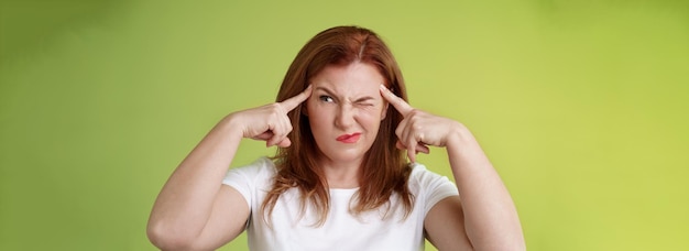 Decisão difícil perplexo hesitante ruiva de meia-idade mulher tentando resolver quebra-cabeça olhar perplexo