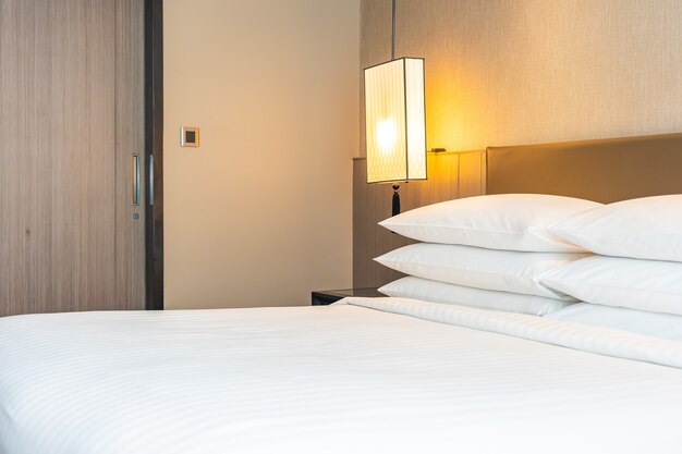 Decoração branca de travesseiro e cobertor confortável no interior da cama do quarto