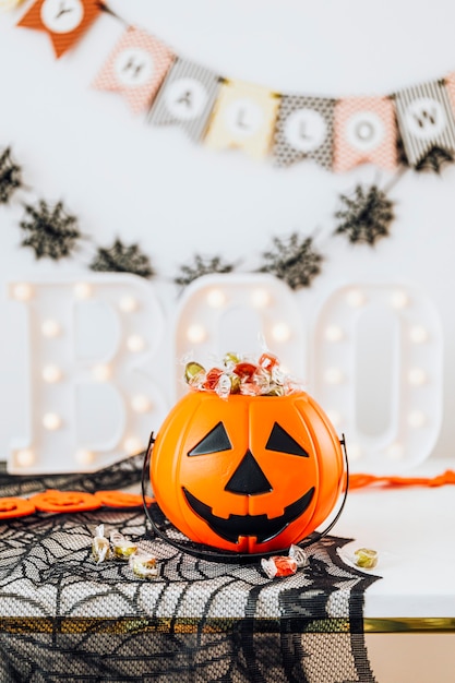 Decoração de Halloween com cesta de abóbora cheia de doces