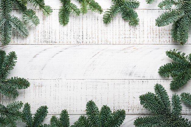 Decoração de natal. decorações do feriado com enfeites de ouro, cones, sinos, ramos de abeto e presentes no fundo da placa de madeira branca velha. projeto de borda. vista do topo. brincar.