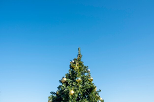 decoração de ouro na árvore de natal e céu azul