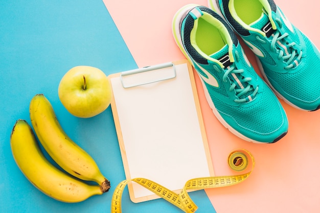 Decoração de treinamento com prancheta, sapatos e frutas