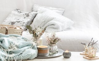Foto grátis decoração para casa no interior. cobertor turquesa e cesta de vime com um vaso de flores e velas
