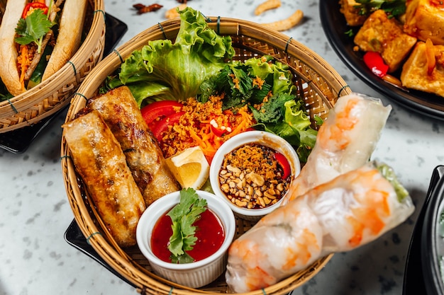 Deliciosa comida vietnamita, incluindo Pho ga, macarrão, rolinho primavera na parede branca