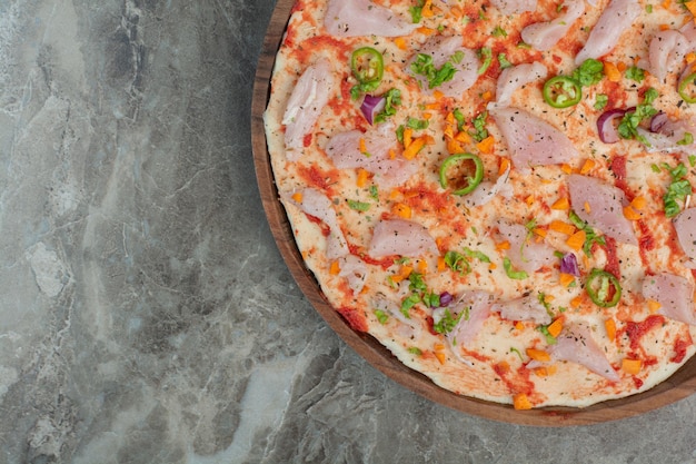 Foto grátis deliciosa pizza com carne de frango na placa de madeira. foto de alta qualidade