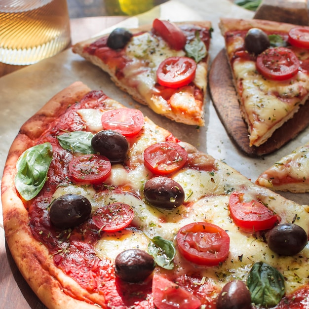 Deliciosa pizza com queijo e fatias de tomate cereja na mesa de madeira