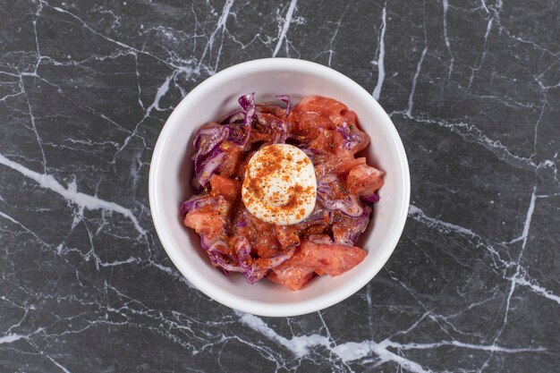 Foto grátis deliciosa refeição com carne em um prato branco sobre uma bola de gude.