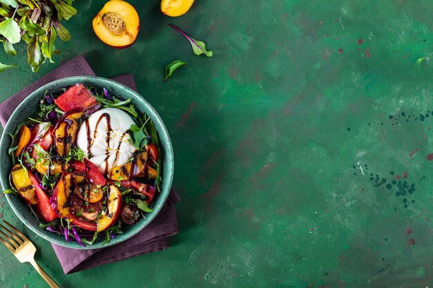 Deliciosa salada de verão com queijo burrata e pêssegos grelhados rúcula e microgreens