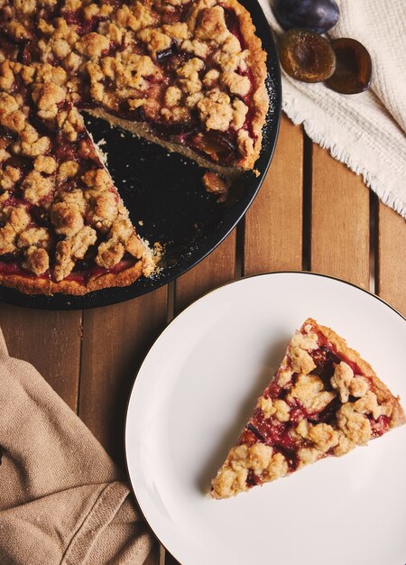 Deliciosa torta de ameixa com café Chemex e ingredientes com tecido em uma mesa de madeira com tecido