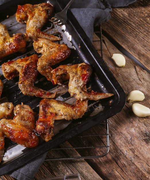 Deliciosas asas de frango na mesa de madeira