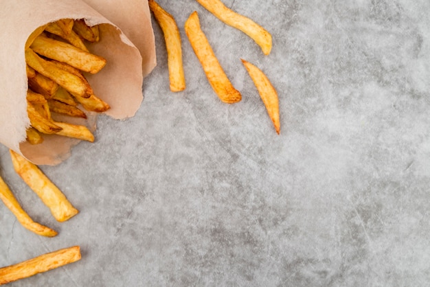 Foto grátis deliciosas batatas fritas na mesa cinza