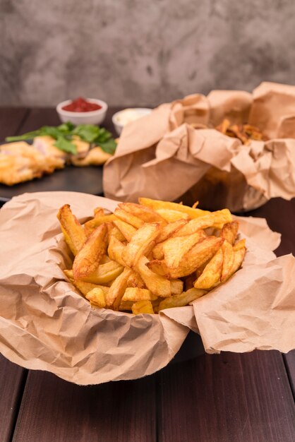 Deliciosas batatas fritas na mesa de madeira