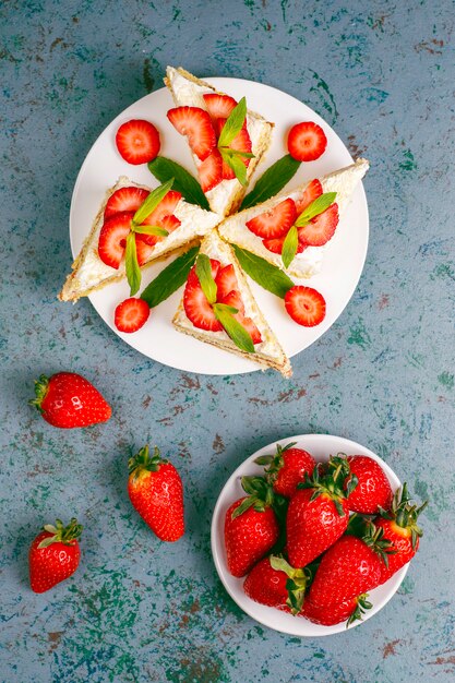 Deliciosas fatias de bolo caseiro de morango com creme e morangos frescos