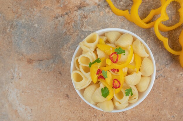 Deliciosas fatias de macarrão e pimenta em fundo laranja