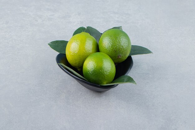 Deliciosas frutas com limão em uma tigela preta