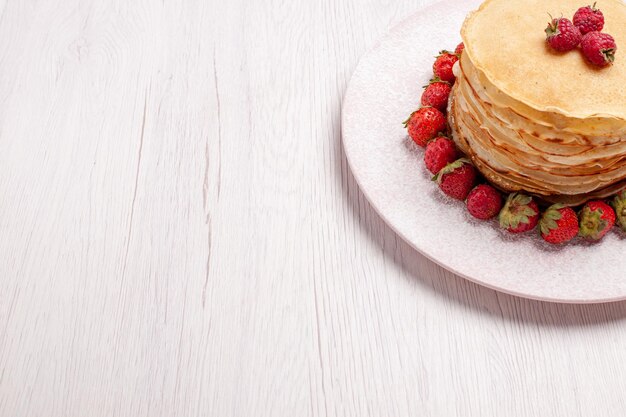 Deliciosas panquecas de vista frontal com morangos vermelhos frescos no espaço em branco