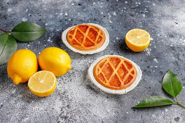 Deliciosas tortas de limão com limões frescos, vista superior