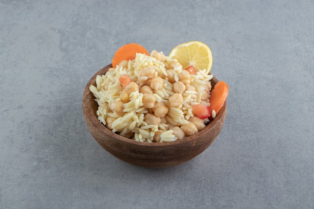 Delicioso arroz com grão de bico em uma tigela de madeira.