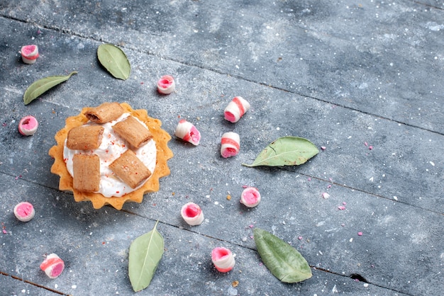 Delicioso bolo cremoso com biscoitos junto com balas fatiadas em cinza, bolo doce assar creme