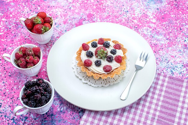 delicioso bolo cremoso com diferentes frutas frescas em uma mesa iluminada, frutas vermelhas frescas