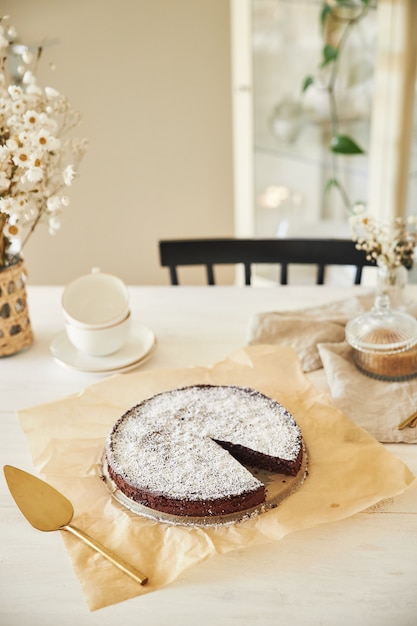 Delicioso bolo de chocolate com creme sobre uma mesa branca apresentada com detalhes estéticos