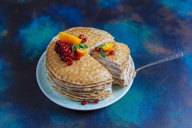 Foto grátis delicioso bolo de crepe caseiro decorado com sementes de romã e tangerinas.