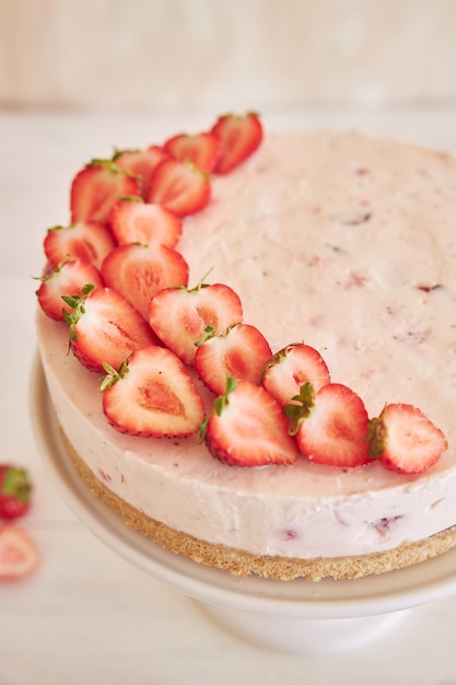 Delicioso bolo de iogurte gelado com fundo de biscoito e morangos