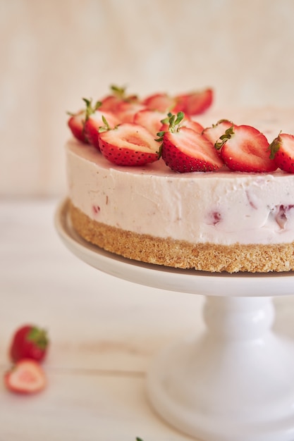 Foto grátis delicioso bolo de iogurte gelado com fundo de biscoito e morangos