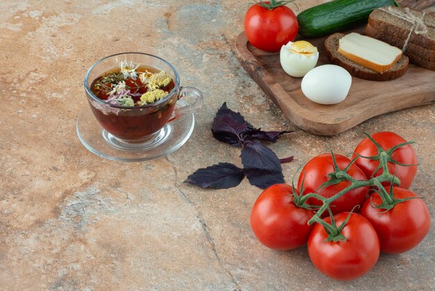 Delicioso chá de camomila com tomate e pão.