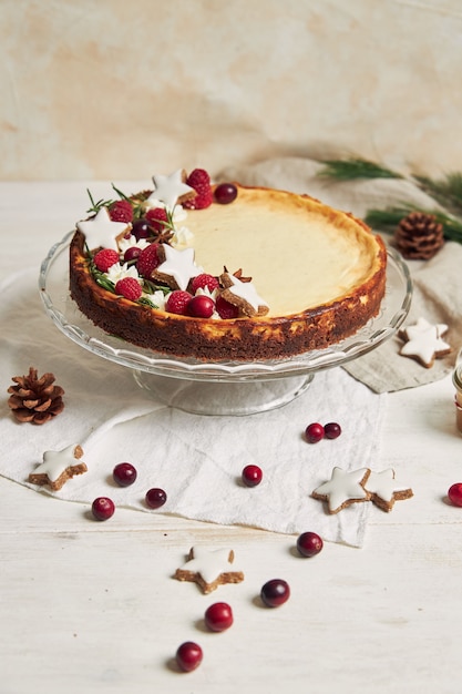 Delicioso cheesecake de Natal com estrelas de cranberries e biscoitos em uma mesa branca