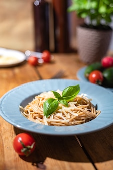 Delicioso espaguete em um prato azul. comida lenta saudável caseira. tradições familiares