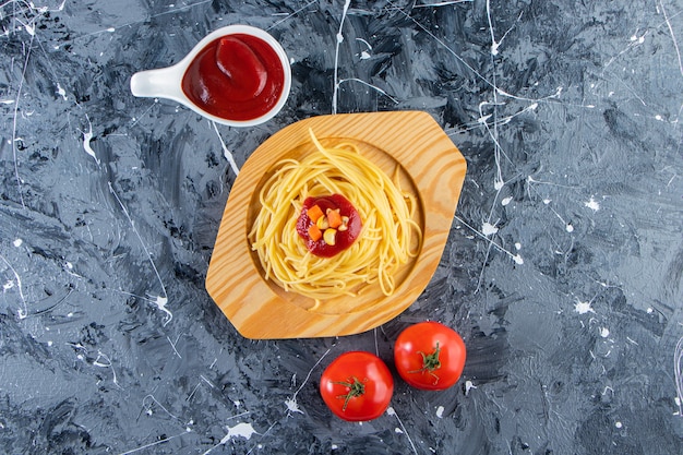 Delicioso espaguete na placa de madeira com tomate fresco e molho de tomate.