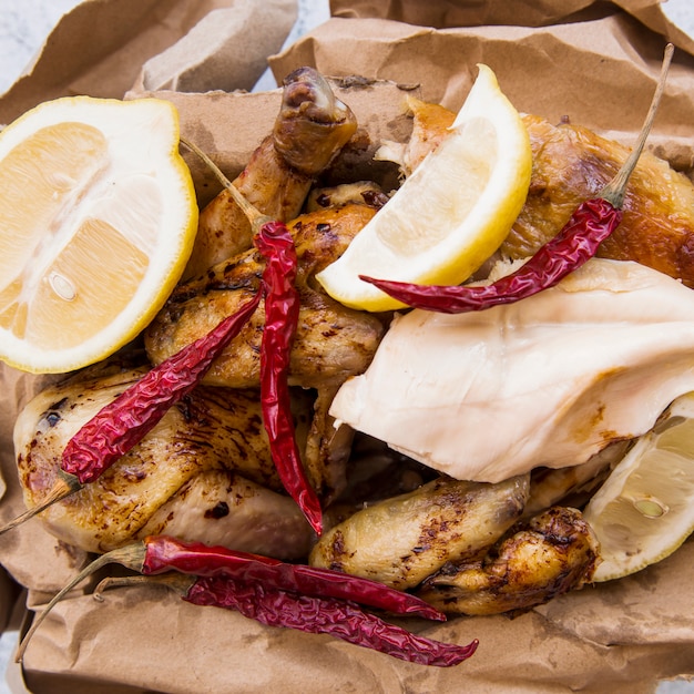 Delicioso frango assado com limão e pimentões vermelhos em papel pardo