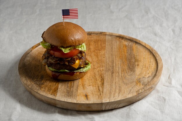 Delicioso hambúrguer com bandeira dos eua na placa de madeira