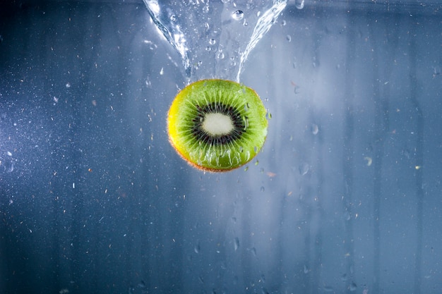 Foto grátis delicioso kiwi na água com fundo azul