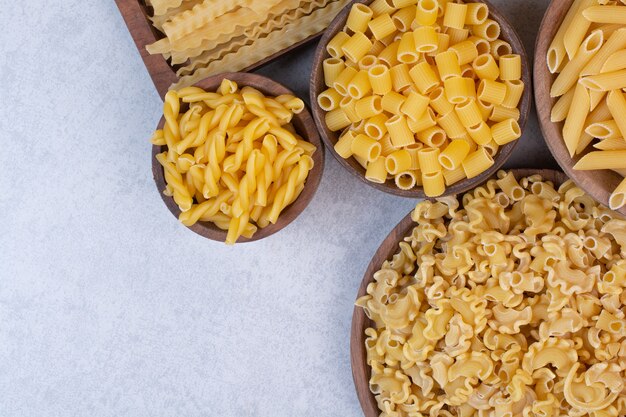 Delicioso macarrão cru e vermicelli em tigelas de madeira